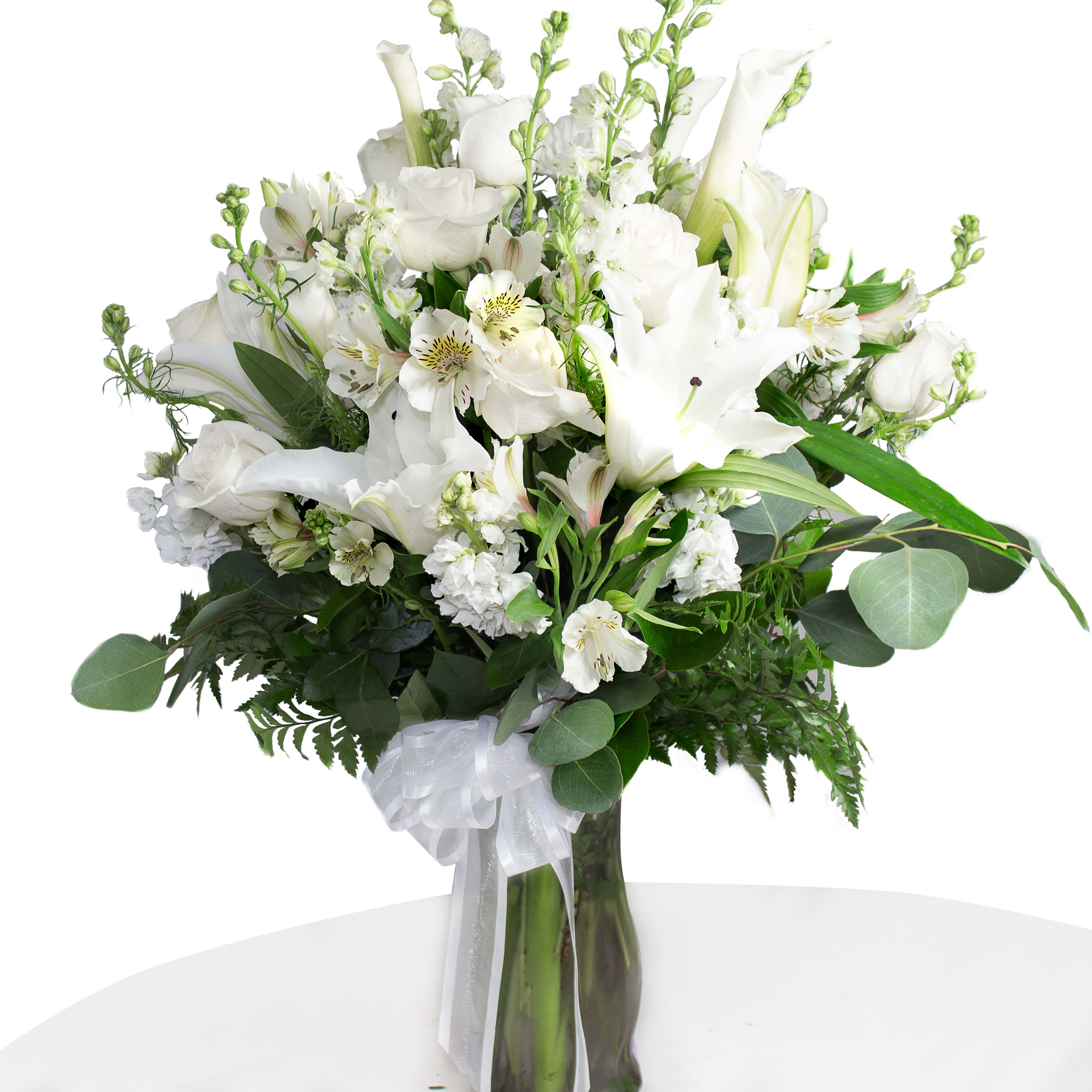 White floral bouquet in a glass vase with a sheer ribbon