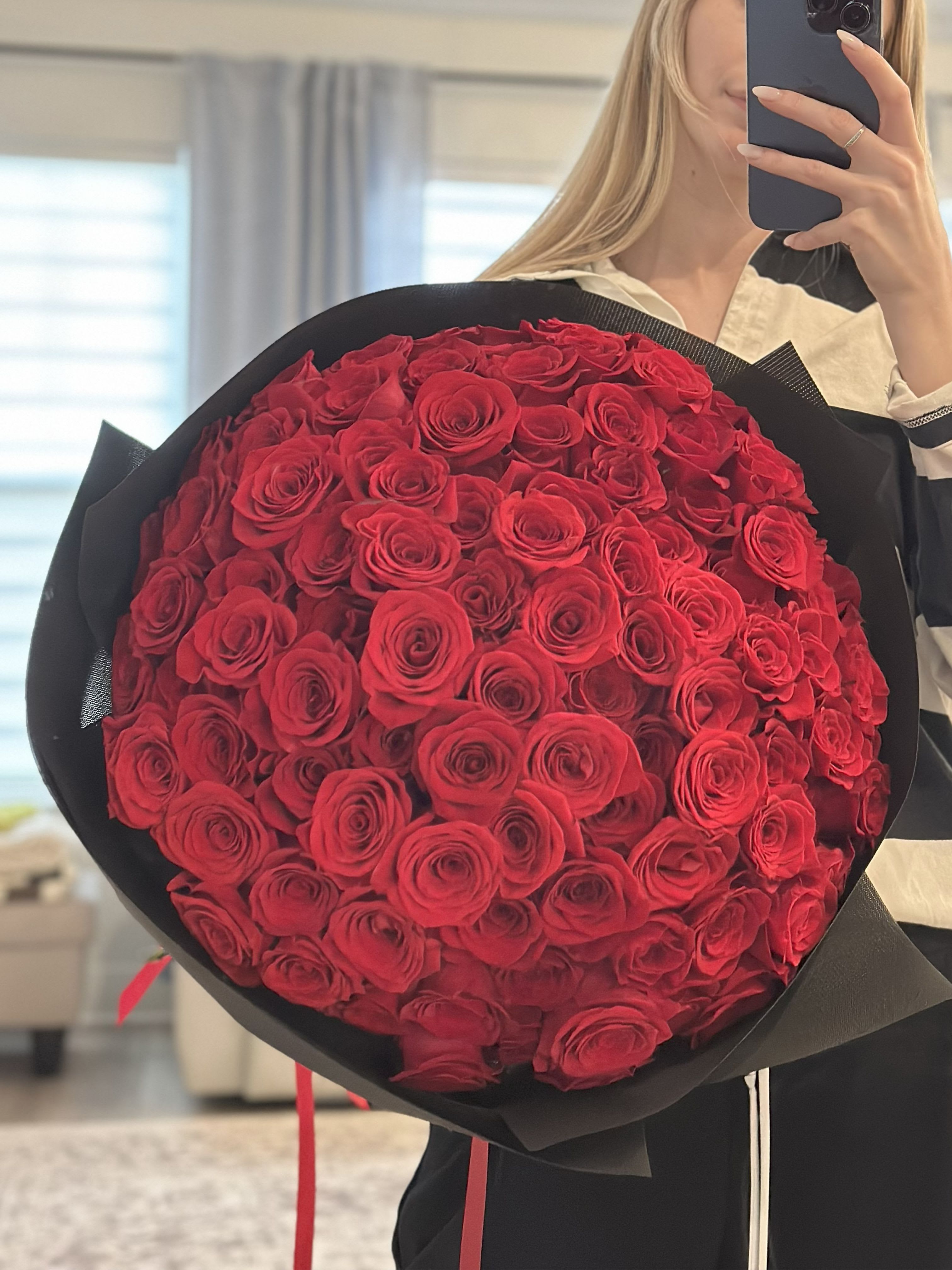 Large bouquet of red roses wrapped in black paper