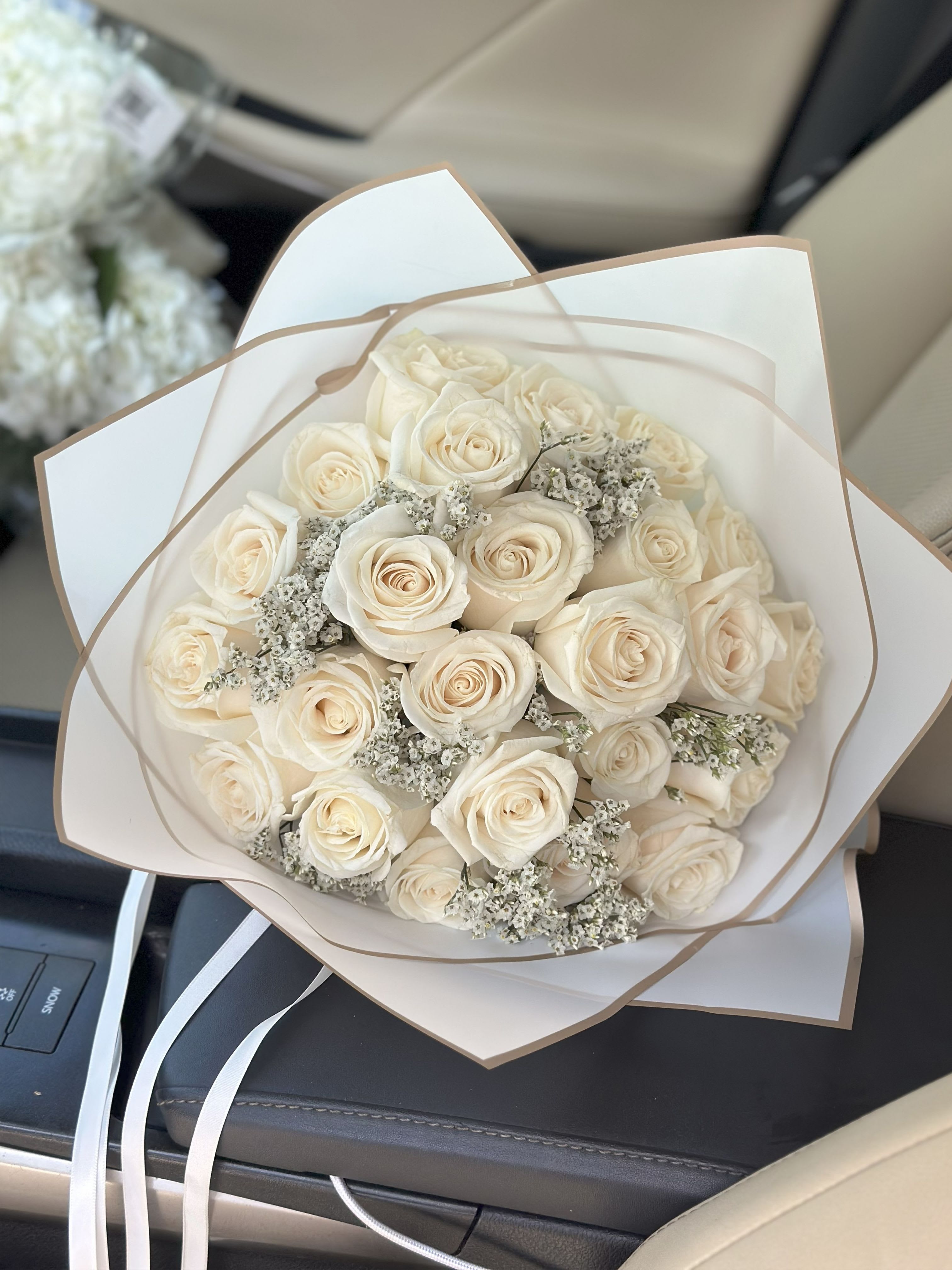 Bouquet of cream roses wrapped in white paper