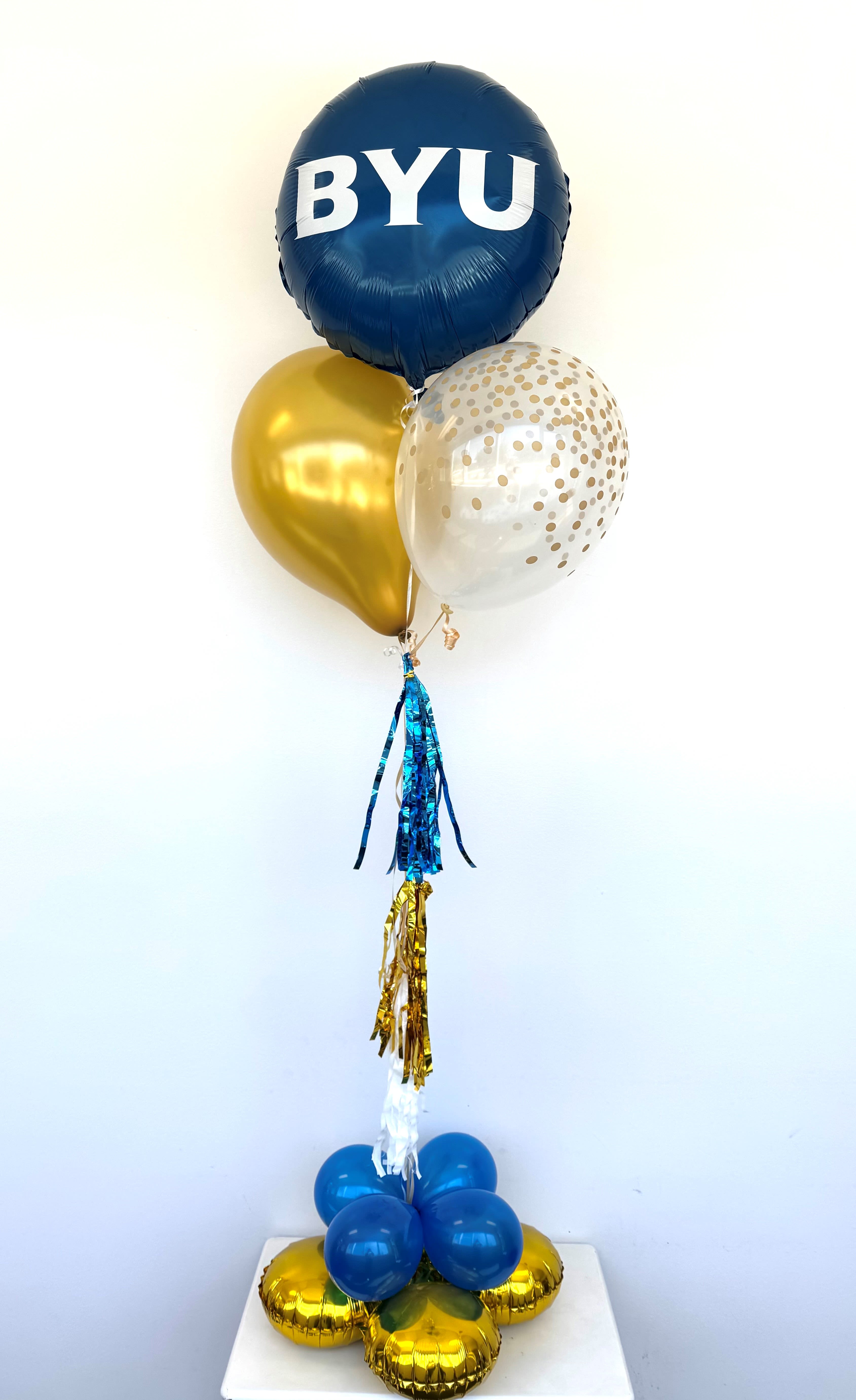 Table top Celabrate 150! - Celebrate Cougar pride in style with our BYU-themed tabletop balloon bouquet! Perfect for graduations, alumni events, or any BYU celebration, this eye-catching arrangement. Make your event unforgettable with a pop of school spirit and a whole lot of blue and white! This festive bouquet includes: 1 BYU Mylar, 1 printed, 1 plain latex balloon, 1 tassel attached to 1 gold myalar quad.