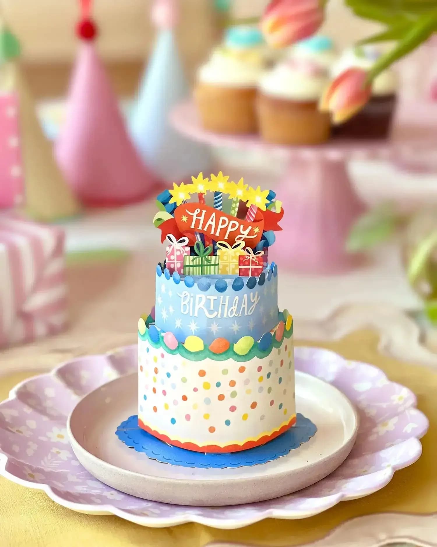 Tiered birthday cake with colorful decorations and a "Happy Birthday" topper