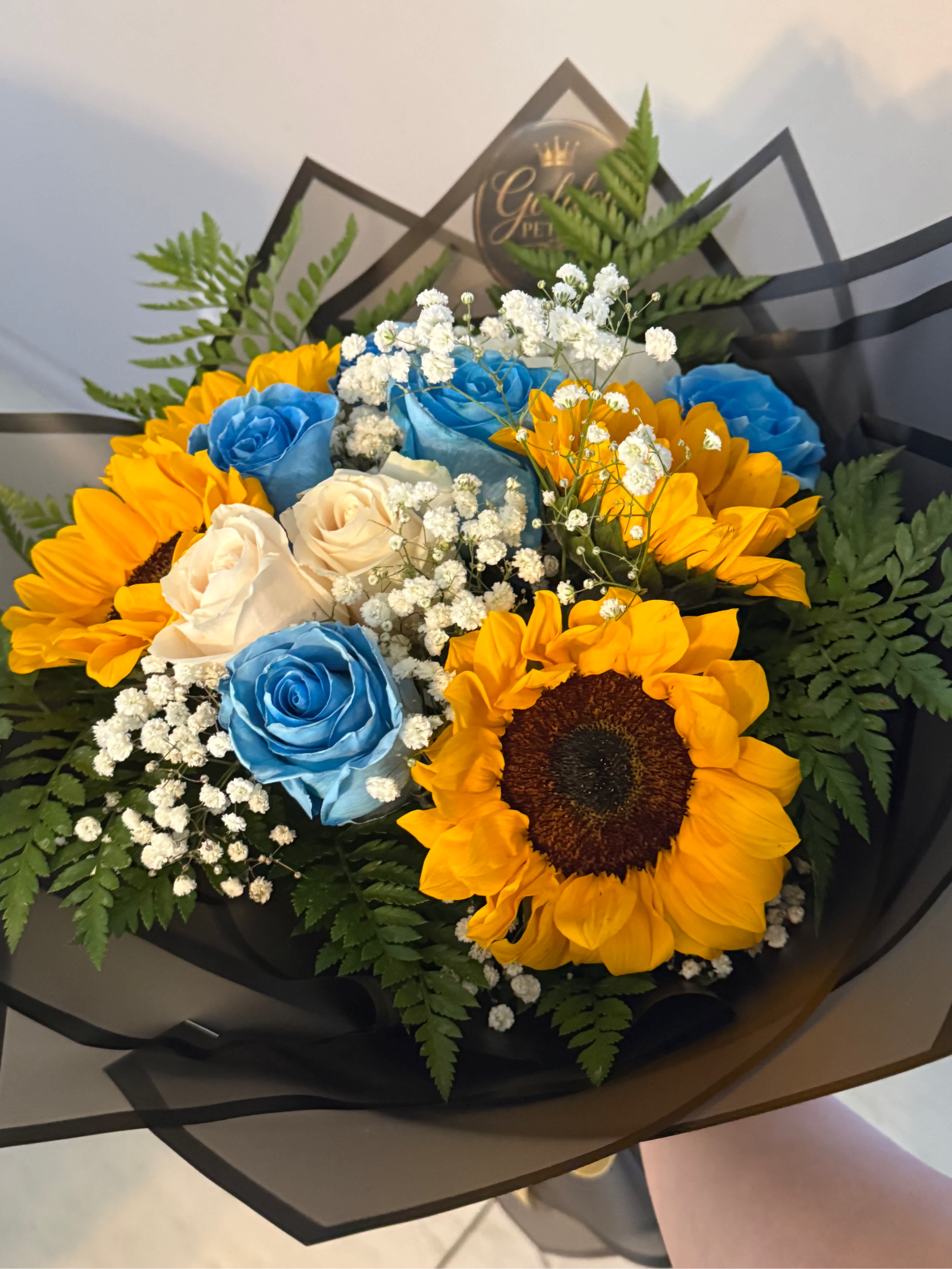 Bouquet of blue and white roses with sunflowers and baby's breath