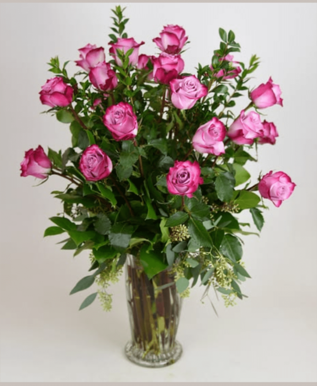 Zelena - A tall, airy cluster of pink roses in shades from soft blush to deep magenta makes a bright, romantic statement for birthdays, anniversaries, Mother's Day, or just because. This flower arrangement (flower arrangement, everyday bouquet) puts the recipient front and center - she'll feel celebrated and seen when greeted by the lush pink blooms framed by fresh green accents in a simple clear glass vase.  Rich, garden-style stems are arranged upright and loosely for a full, slightly airy silhouette; abundant leafy greenery and delicate filler sprays add height, texture, and a natural, layered look. The clear glass vase keeps the presentation classic and lets the stems show through, creating an elegant yet effortless vibe that suits both formal and casual spaces. Order now for same-week delivery or select a future date to make a thoughtful, romantic impression.