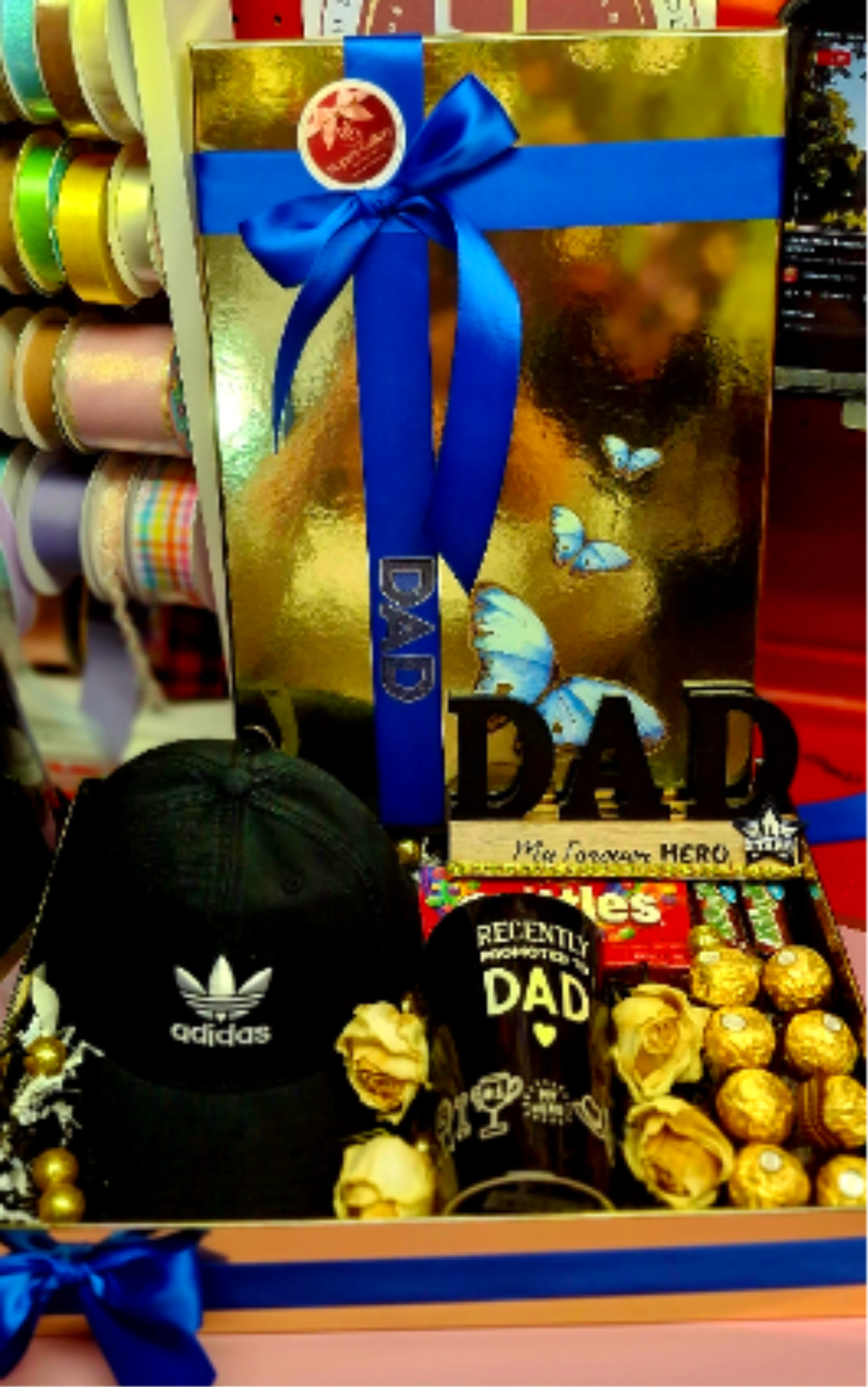 Hero Dad Celebration Box - A thoughtful gift set featuring an Adidas cap, a "Recently Promoted to Dad" mug, sweet treats, and elegant gold-accented decor.