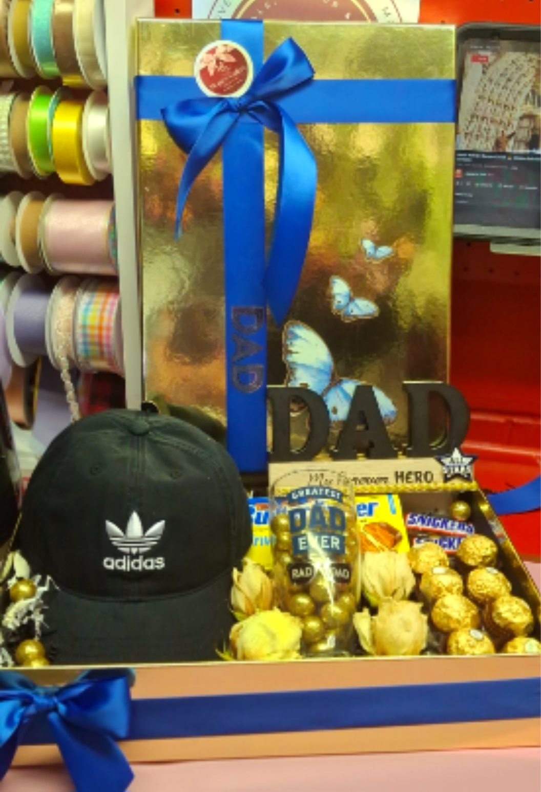 Ultimate Dad Appreciation Set - A curated gift collection featuring an Adidas cap, a "Greatest Dad Ever" glass filled with chocolates, assorted candy bars, and elegant gold-toned floral accents.
