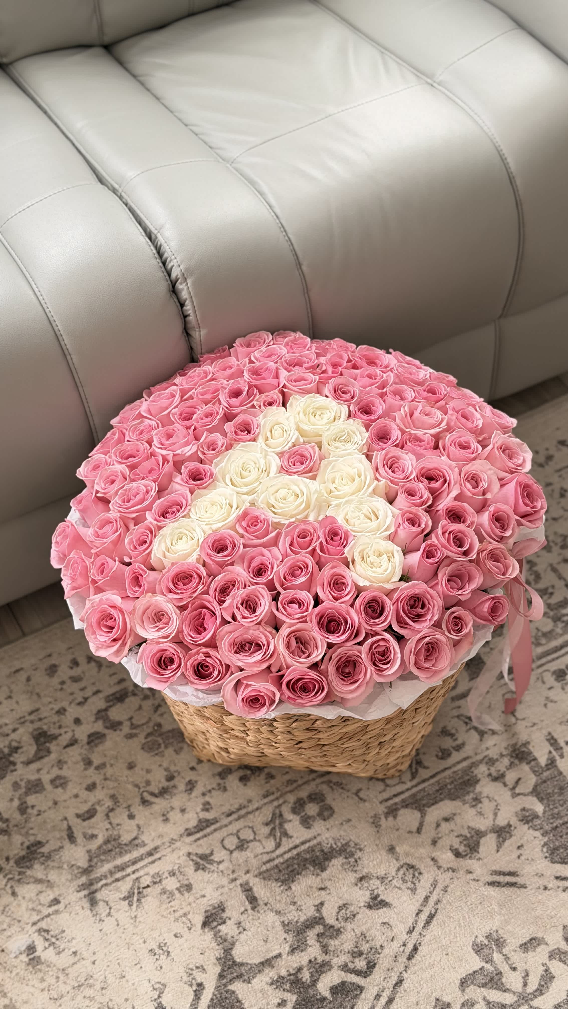 Round basket arrangement of pink and white roses