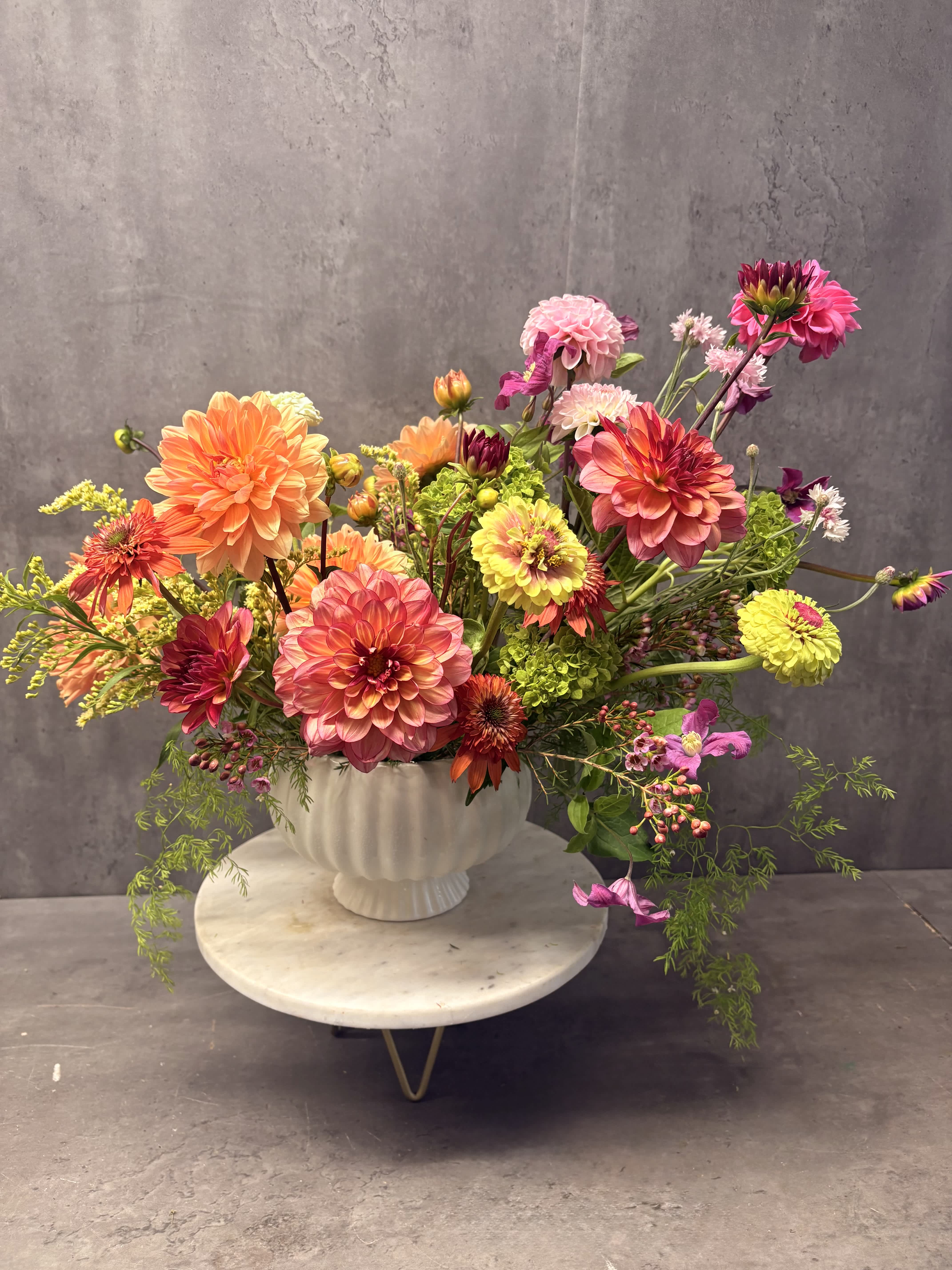 Colorful mixed bouquet of dahlias in a white vase