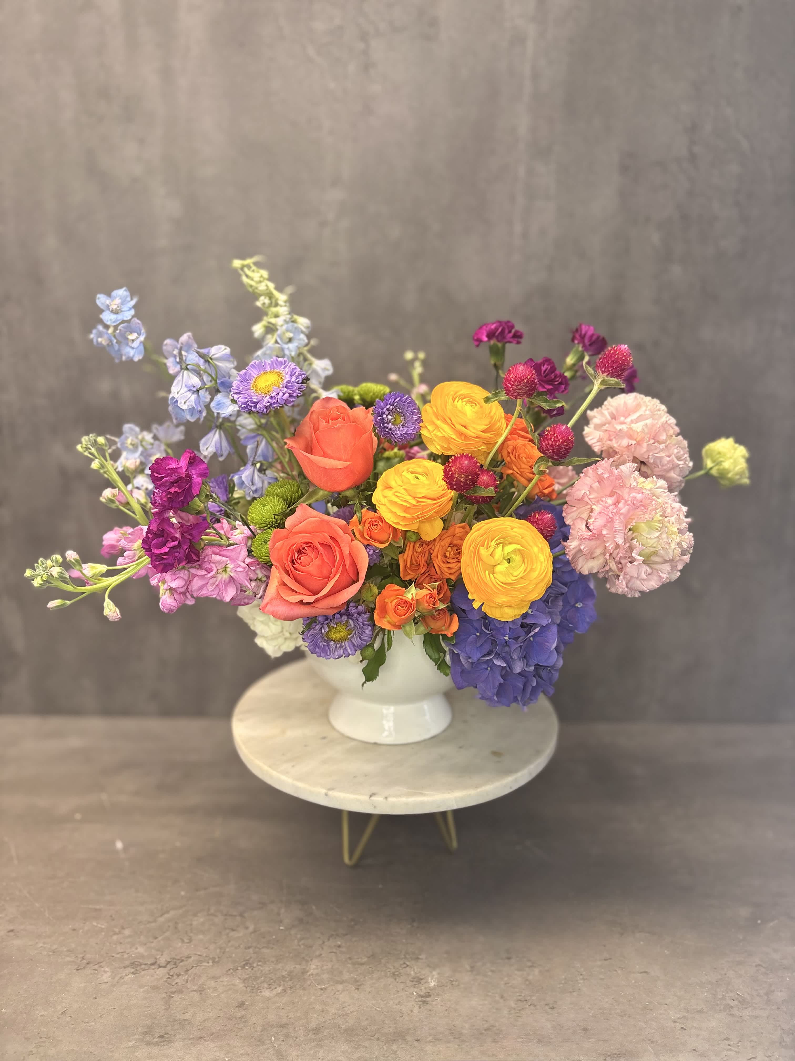 Colorful mixed bouquet in a white pedestal vase