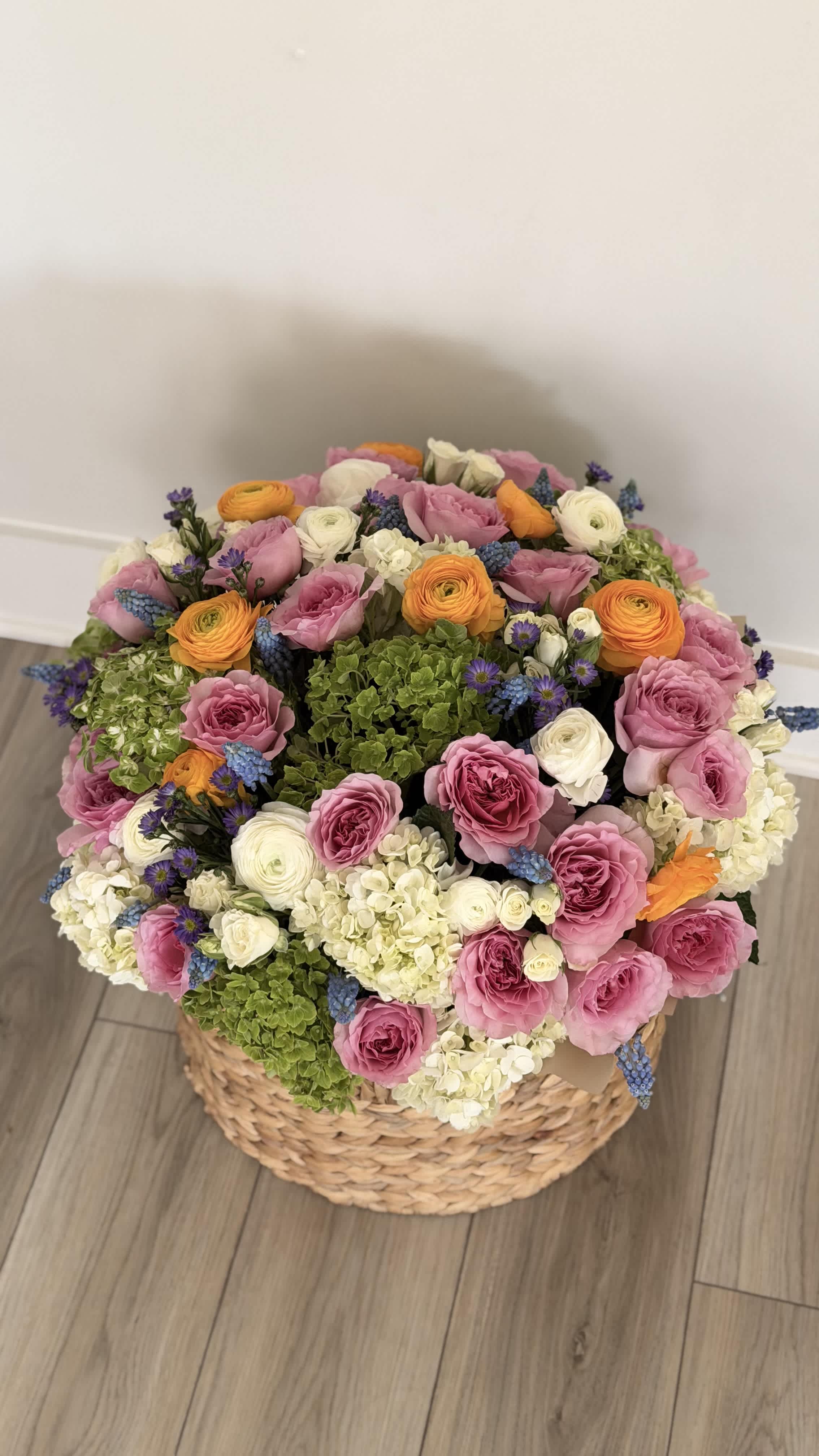 Large basket arrangement of pink, white, orange, and green flowers