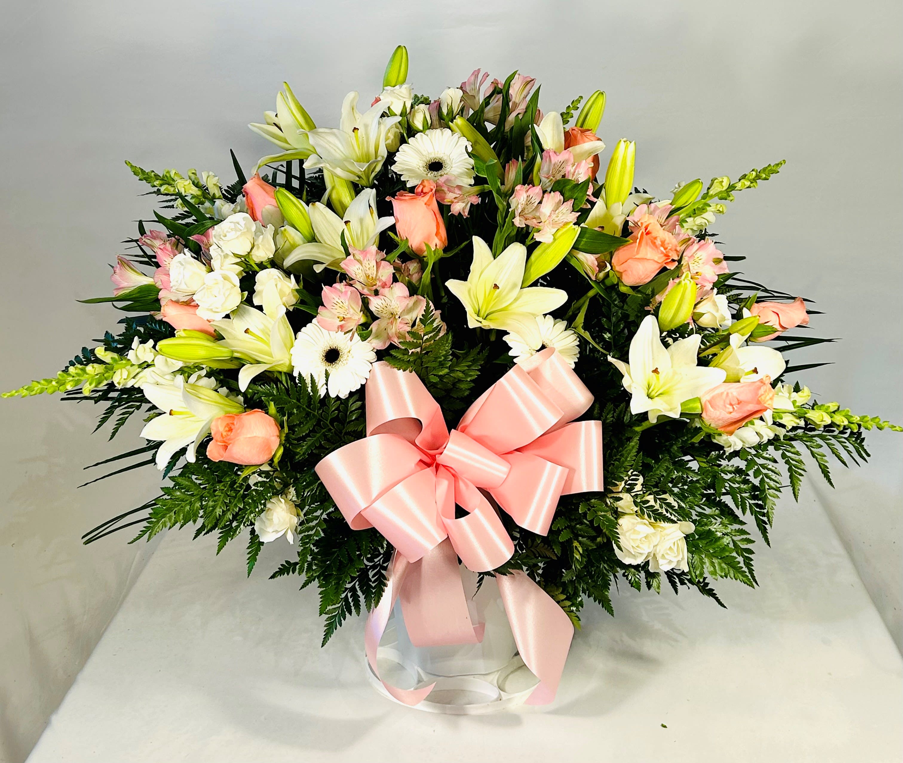 Pink &amp; White Funeral Basket - Send a beautiful expression of your love and concern at this difficult time. Features the freshest pink roses, white lilies, white snapdragons, white gerberas, pink alstroemeria and white sweetheart roses. 