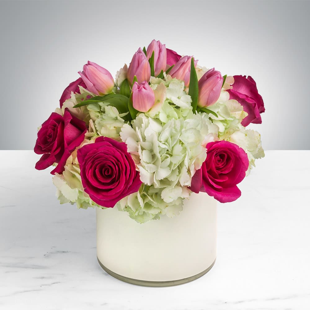 Pink roses and tulips in a white vase