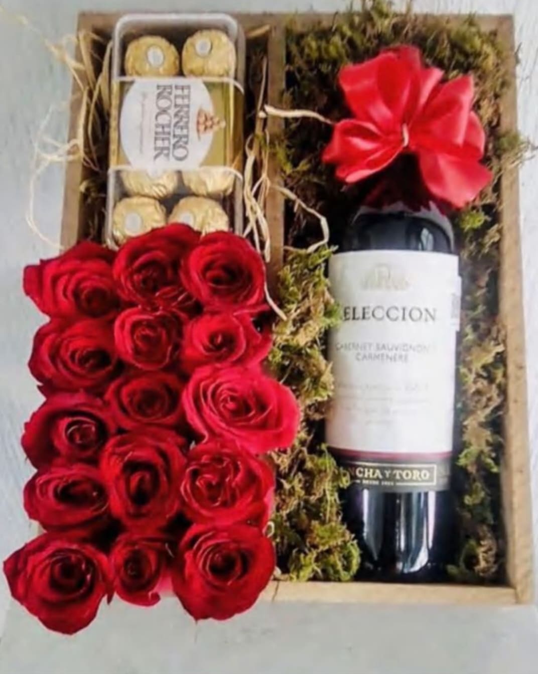 Gift box with red roses, chocolates, and a wine bottle