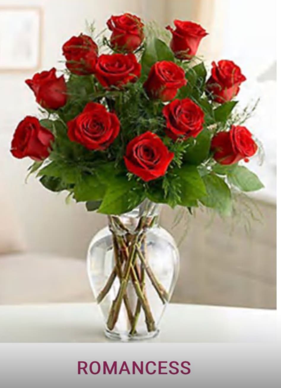 Red roses arranged in a clear glass vase