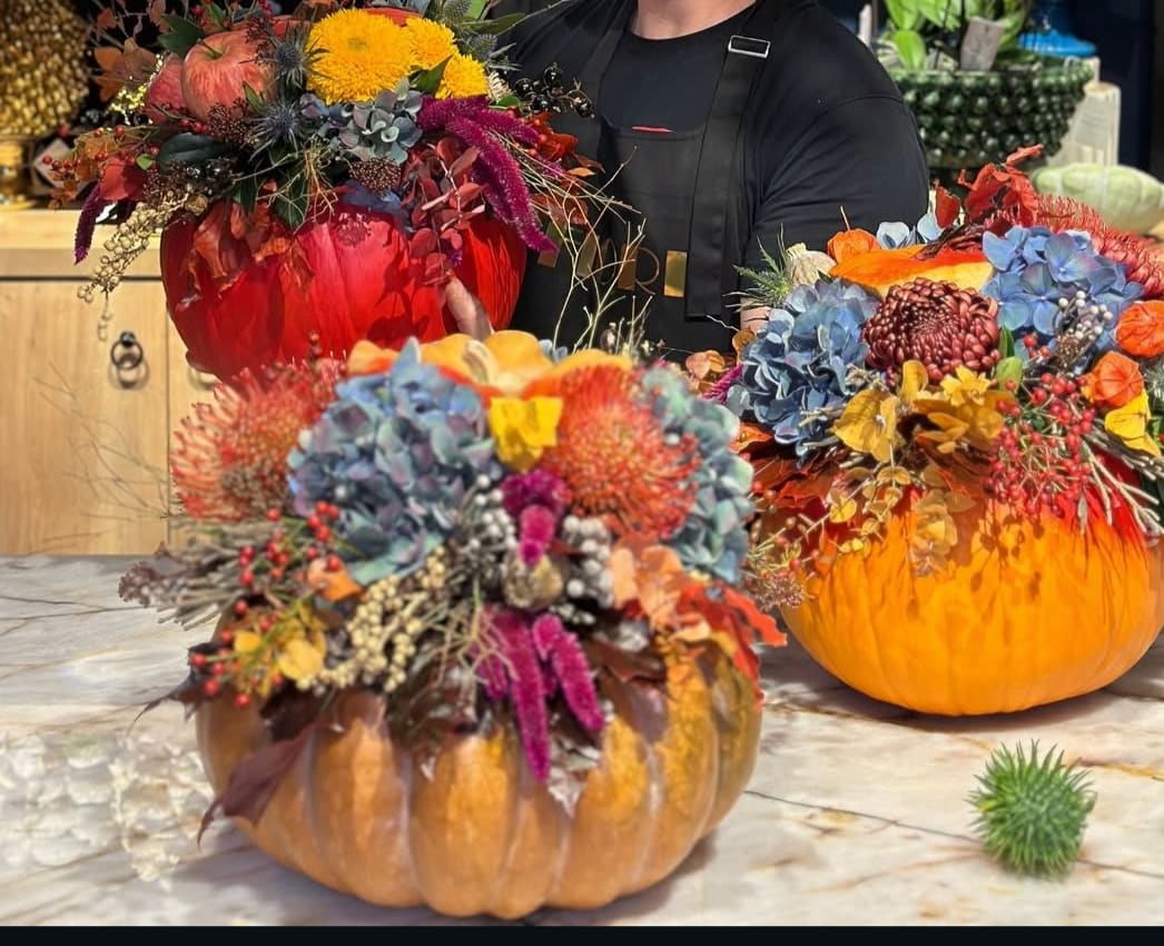 Pumpkin arrangements with colorful flowers and autumn foliage