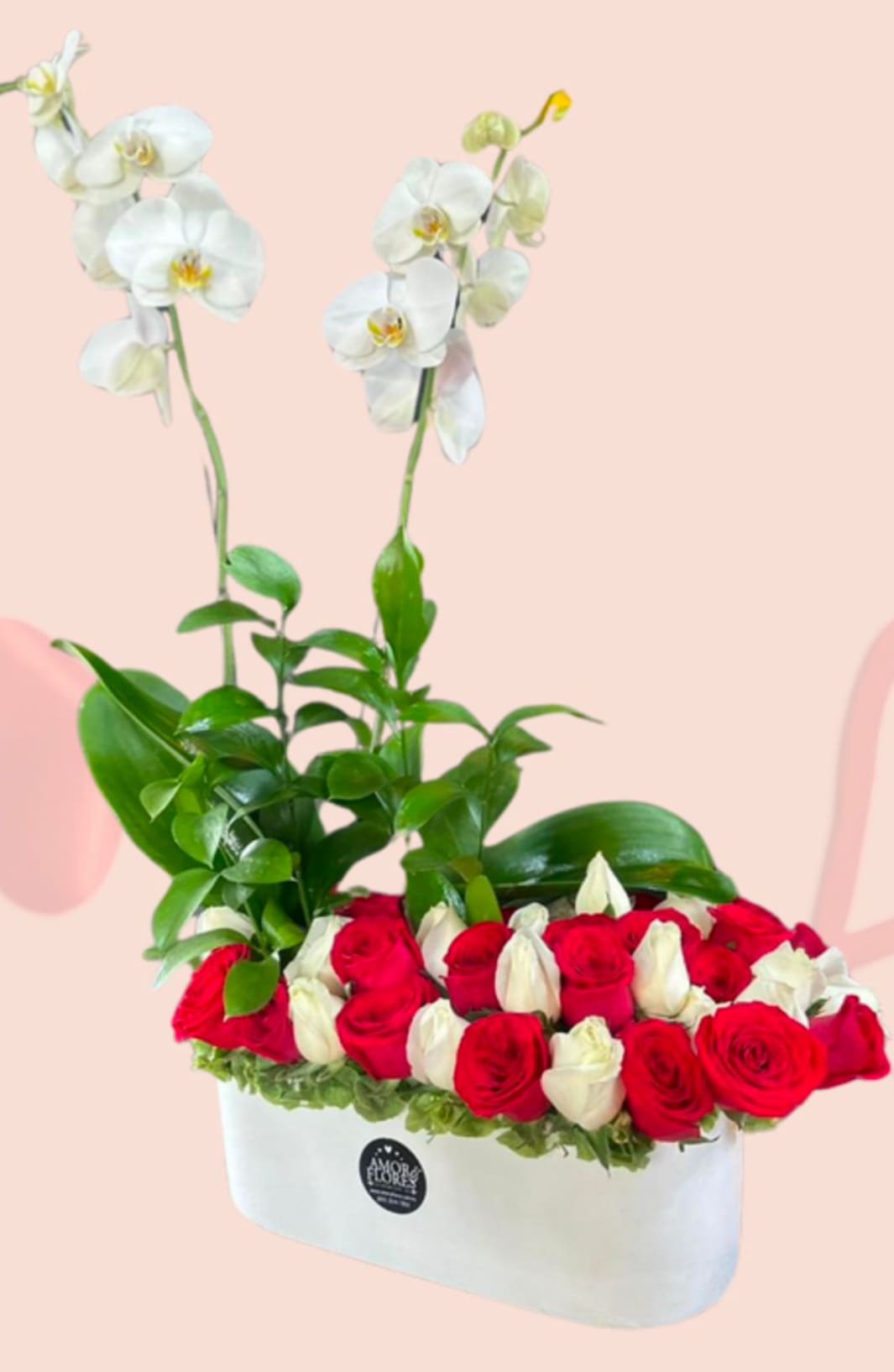 White orchids rise above red and white roses in a white box arrangement.