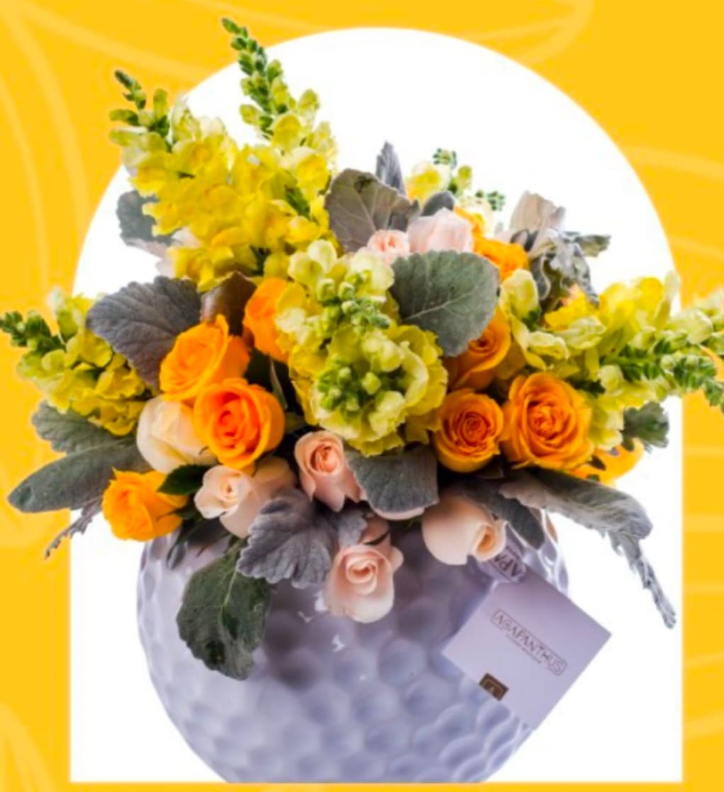 Yellow and orange rose bouquet in a lavender vase with a gift card