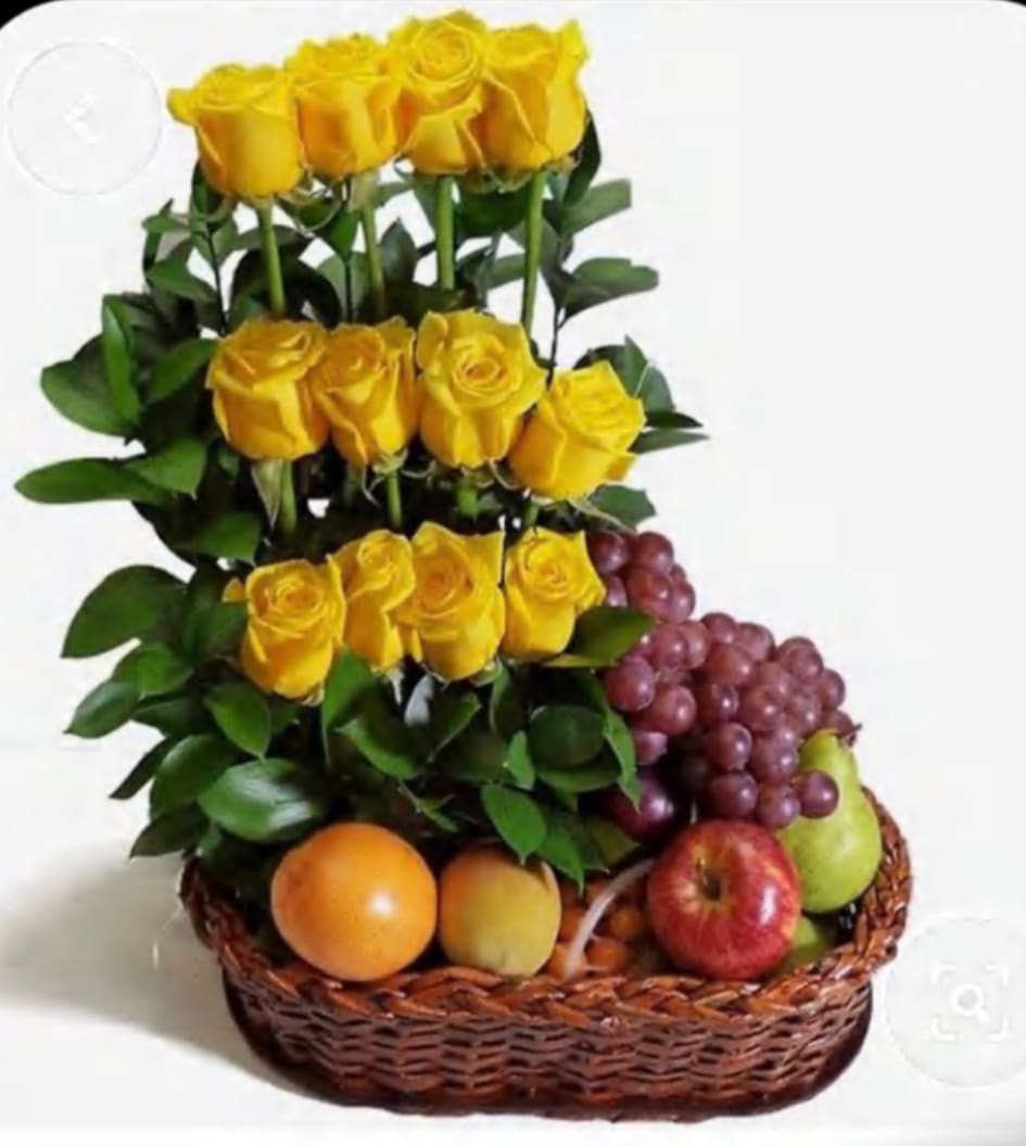 Yellow roses arranged in a basket with assorted fruit