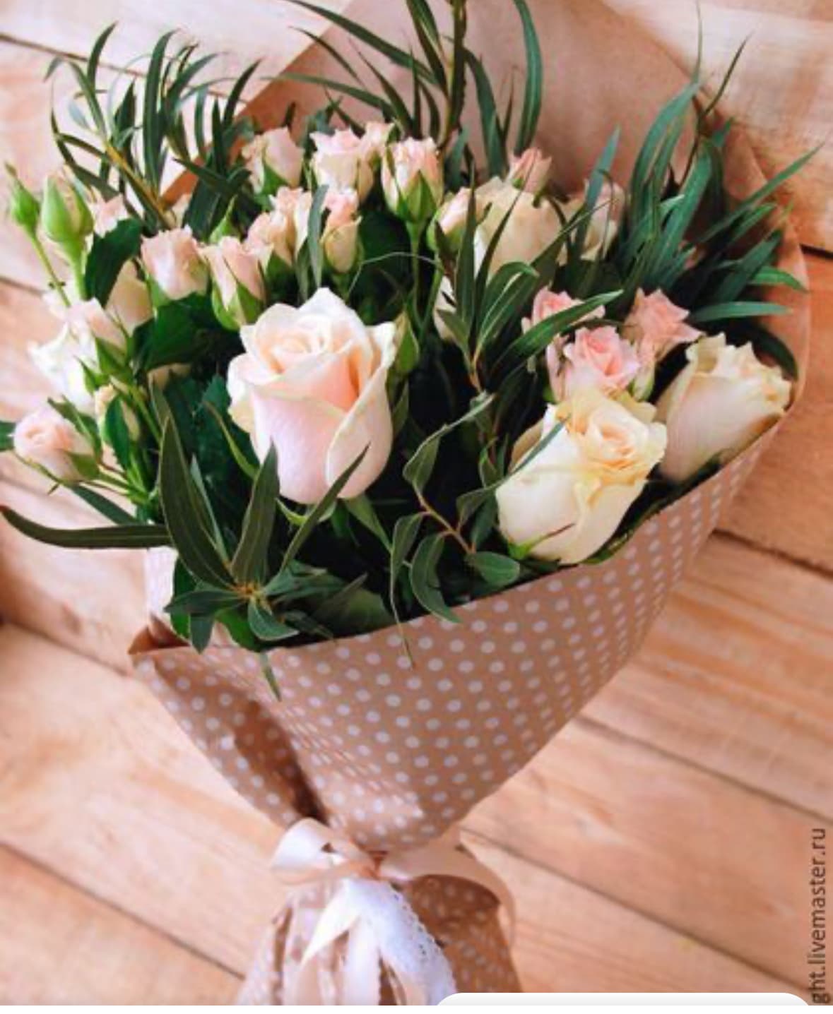 Bouquet of pale pink roses and small pink blooms in polka-dot wrap