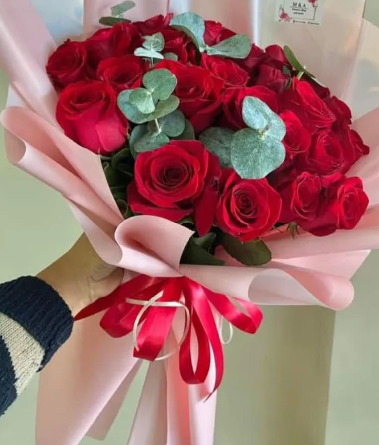 Bouquet of red roses with eucalyptus wrapped in pink paper