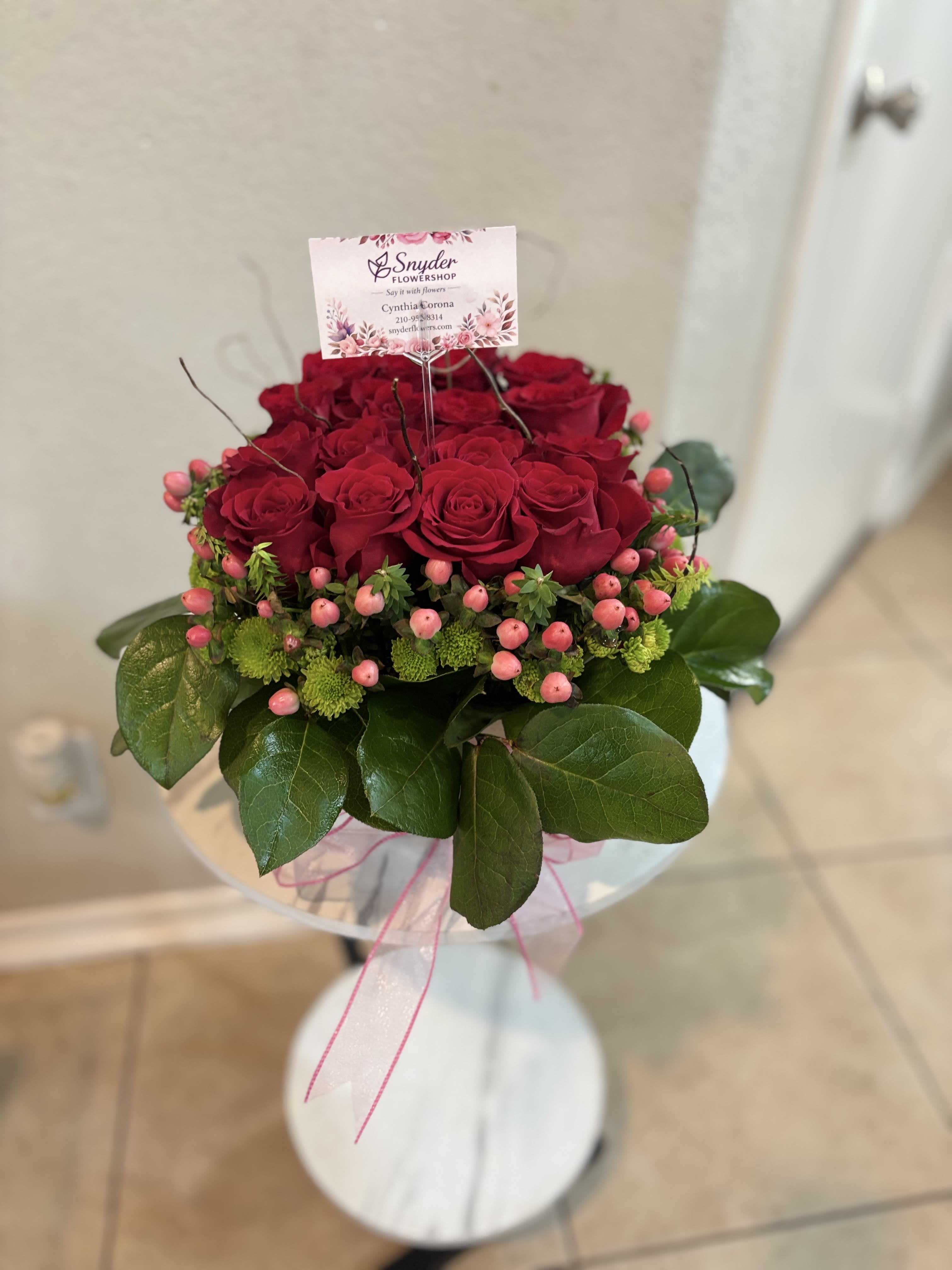 Ruby Romance Rose Bowl - Celebrate love, romance, and meaningful moments with our Ruby Romance Rose Bowl, a luxurious floral design handcrafted by Snyder Flowers in San Antonio, Texas. This elegant arrangement features premium red roses accented with hypericum berries, green button chrysanthemums, decorative branches, and lush greenery arranged in a modern white container. Perfect for anniversaries, Valentine's Day, birthdays, romantic surprises, date nights, engagements, thank you gifts, and special celebrations. Our flower shop proudly offers same-day flower delivery throughout Stone Oak, Alamo Heights, The Dominion, Shavano Park, Medical Center, Helotes, Bulverde, Cibolo, Schertz, Boerne, and all surrounding San Antonio communities. Designed to create unforgettable memories with fresh flowers and exceptional craftsmanship.