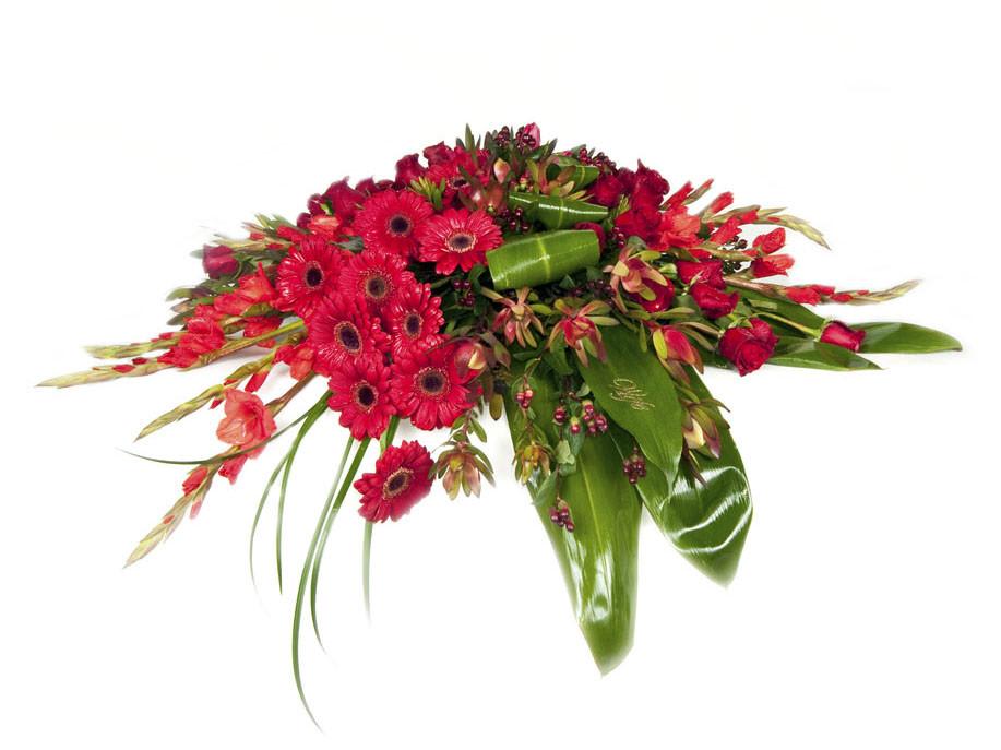 Casket Spray Red - This casket spray is respectful and beautiful for a sympathetic occasion. The arrangement includes red Gerber daisies, red gladiolas, red roses, red hypericum, red leucadendron, ti leaves and lily grass accents. Product availability varies. 