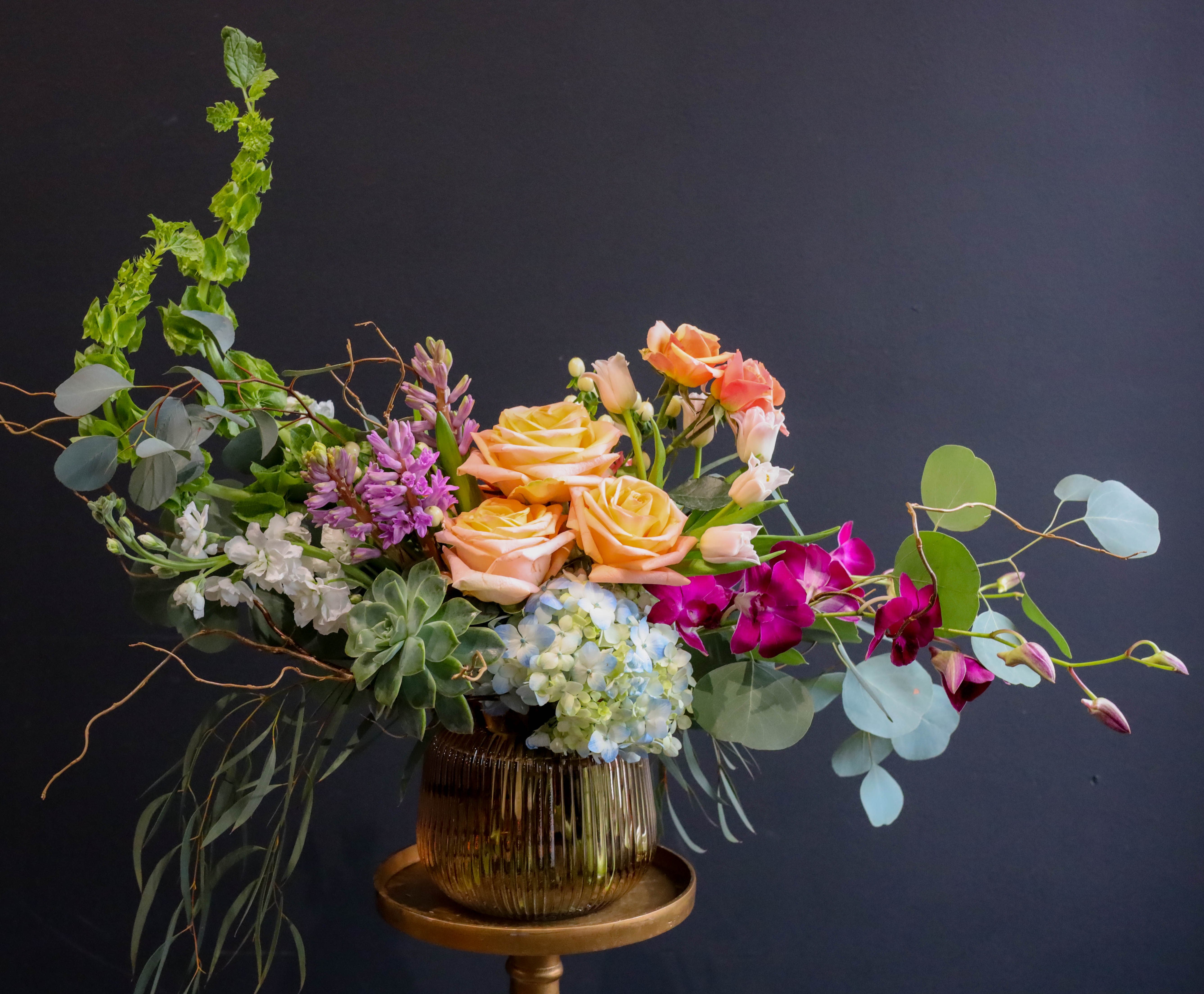 Rose Gold - An arrangement artistically flowing with a variety of premium stems in a limited edition fine rose gold co pressed glass vase! This is definitely a golden choice for your valentine!