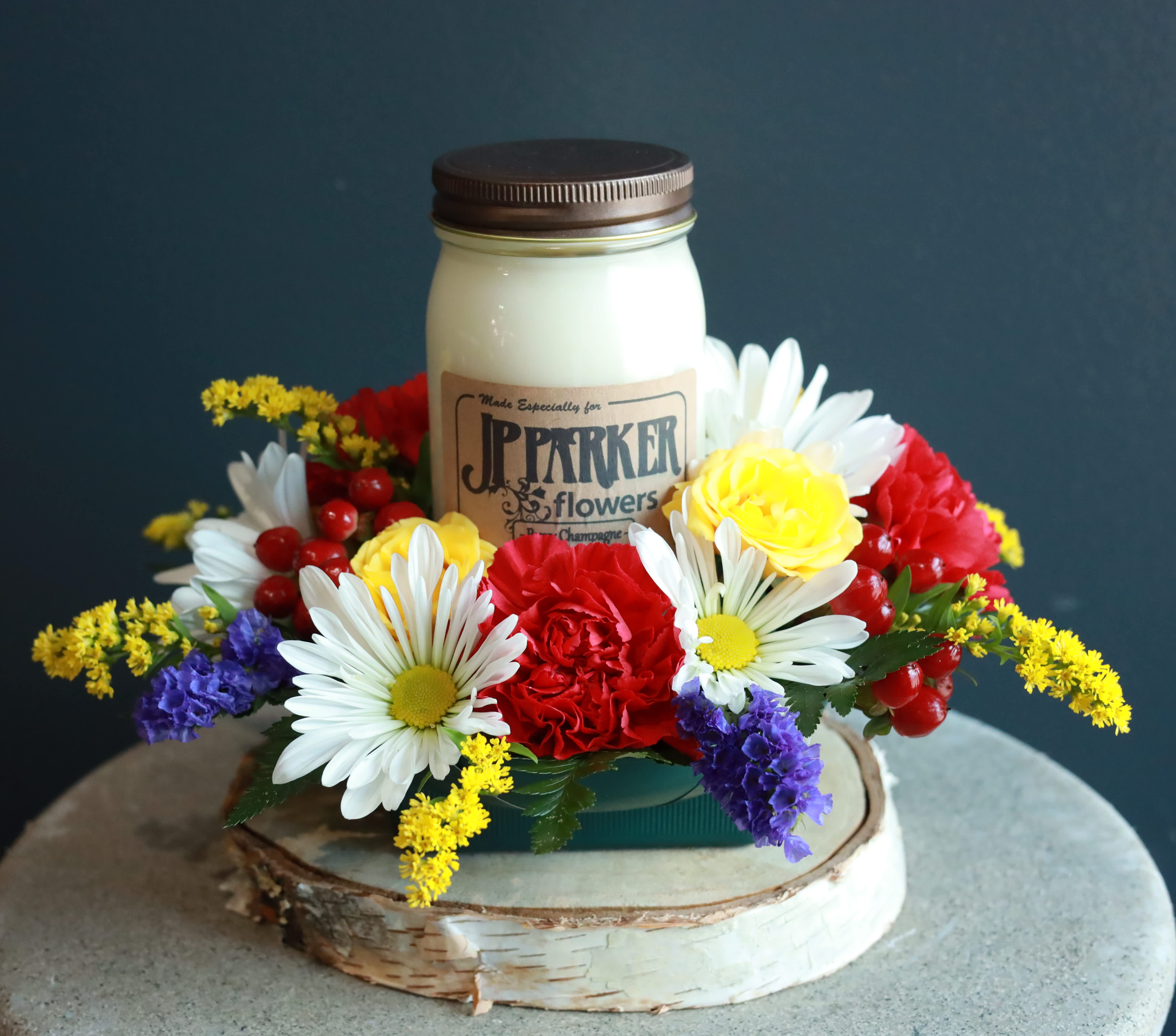 Warm Glow - The love a Mother has is like a warm glow of love, kindness, and affection. This small arrangement with our specialty candle is a wonderful way to return the warmth she has always shown!