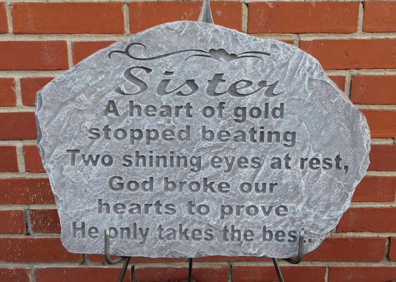 Memorial stone plaque with engraved text on a brick wall