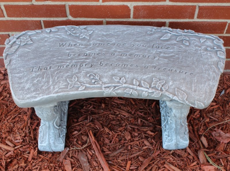 Decorative memorial bench with an engraved quote and floral vine details