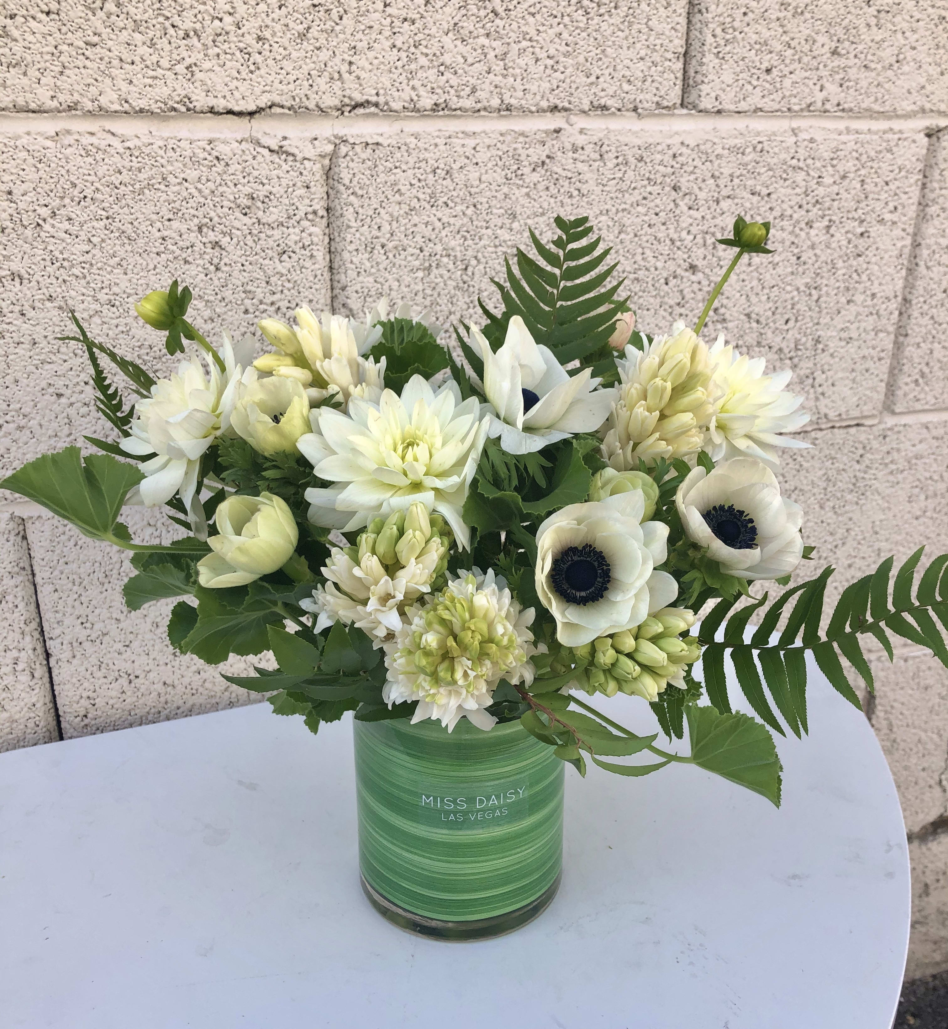 White flowers arranged in a green glass vase