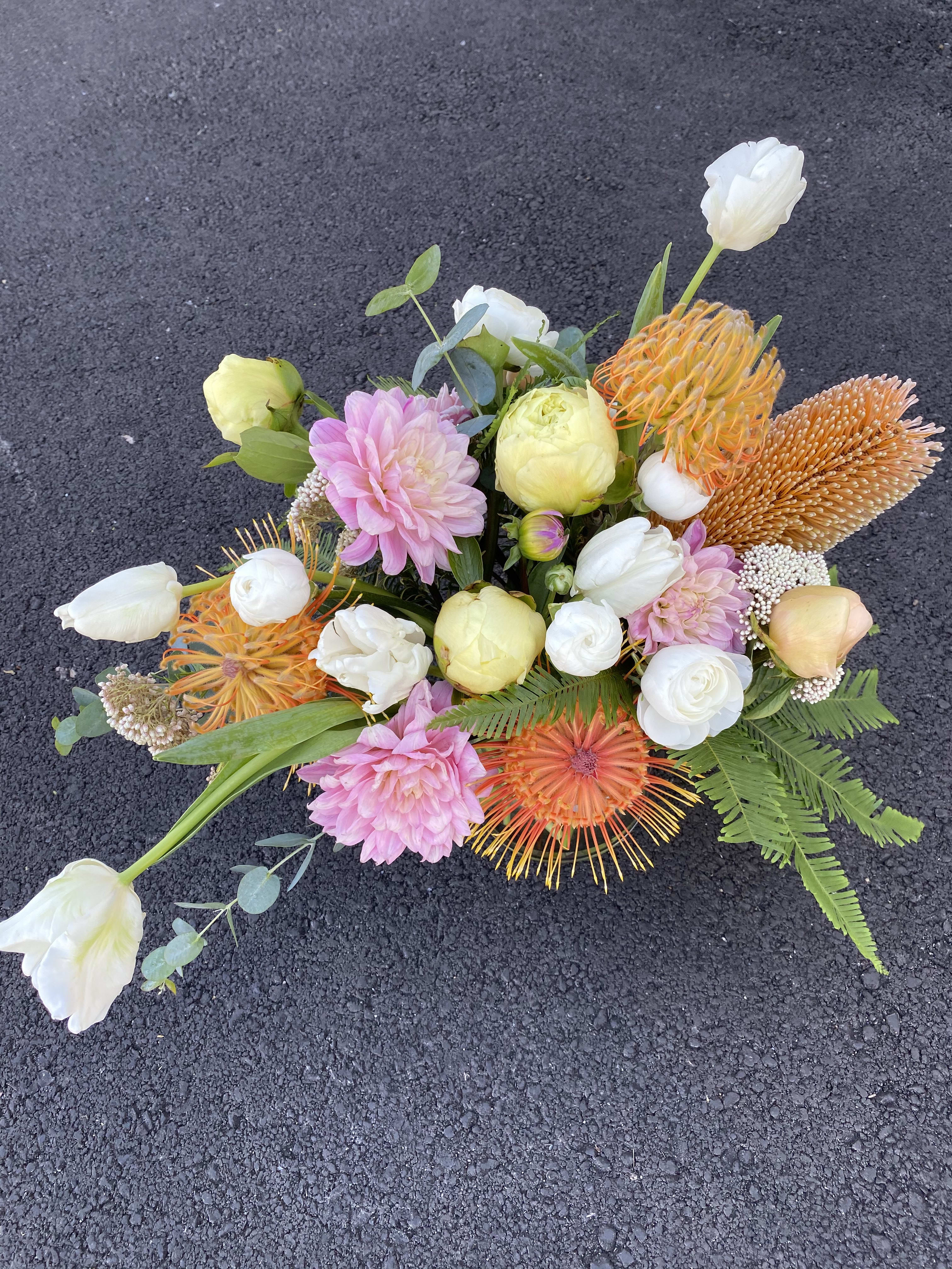 Mixed bouquet with pink, white, and orange flowers on a dark surface