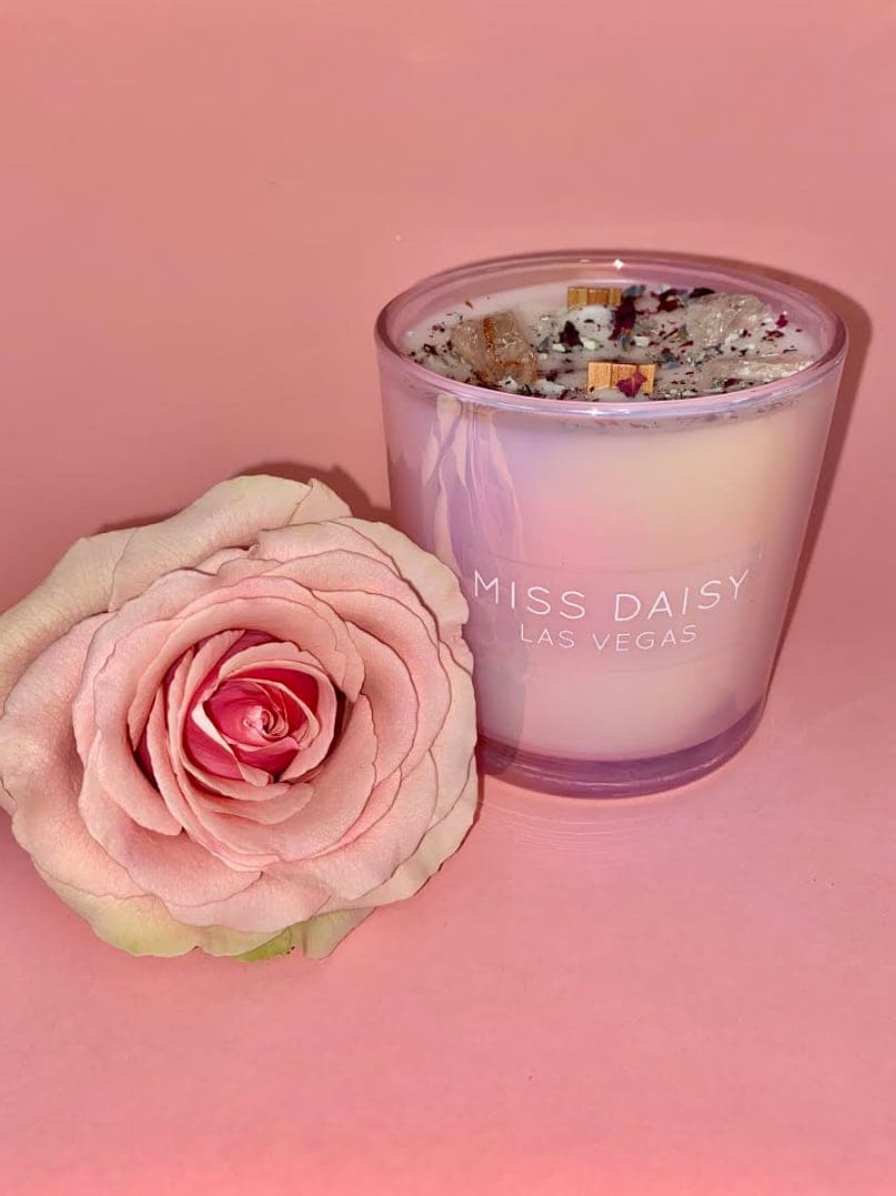 Pink rose beside a lavender glass candle with "Miss Daisy Las Vegas" text