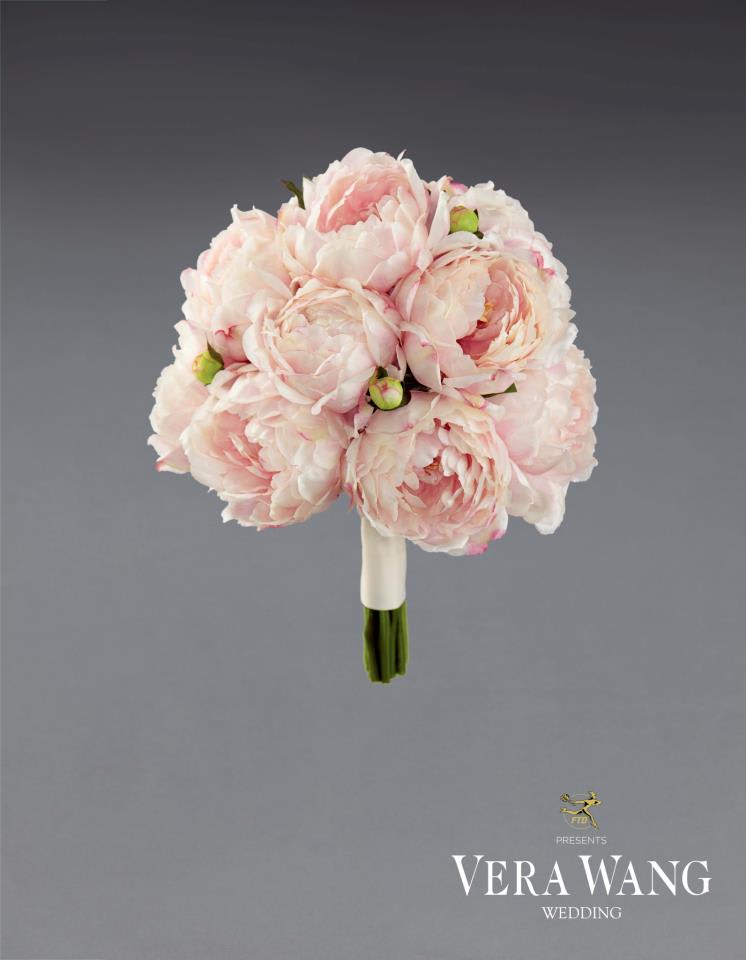 Blush pink peony bouquet with a wrapped handle on a gray background
