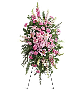 Tall pink and white funeral spray on a stand