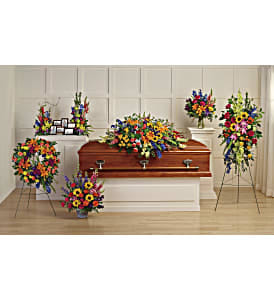 Colorful funeral casket spray with matching standing arrangements