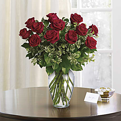 Red roses arranged in a clear glass vase