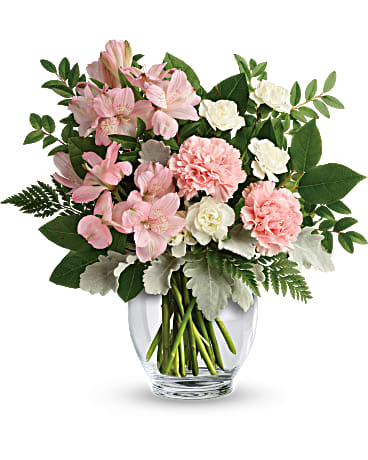 Pink and white flowers arranged in a clear glass vase