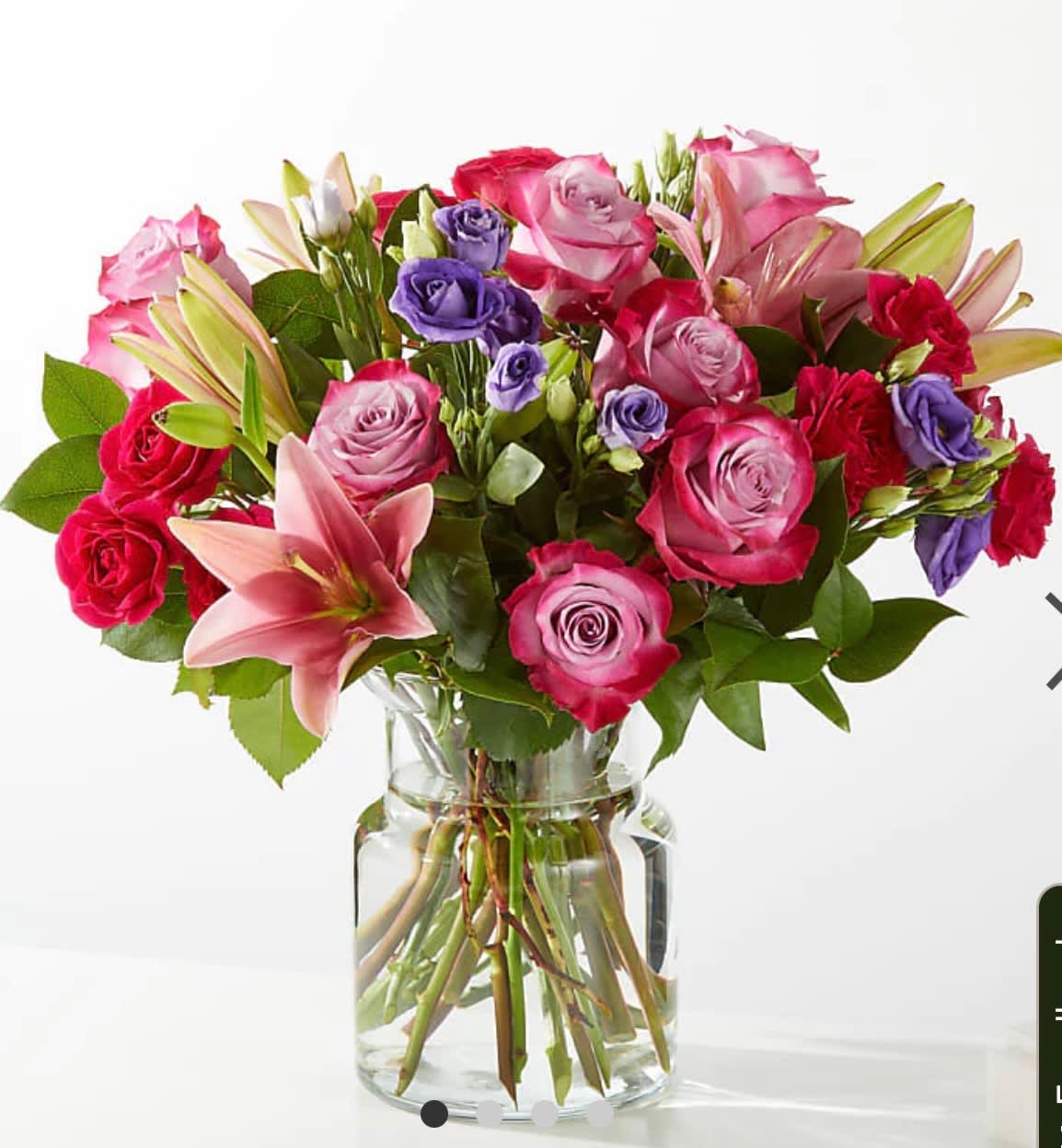 Bouquet of pink and purple roses with lilies in a glass vase