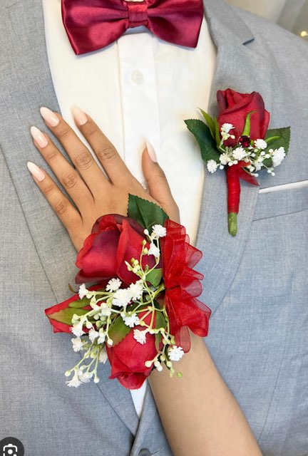 Red rose boutonniere and wrist corsage on a gray suit