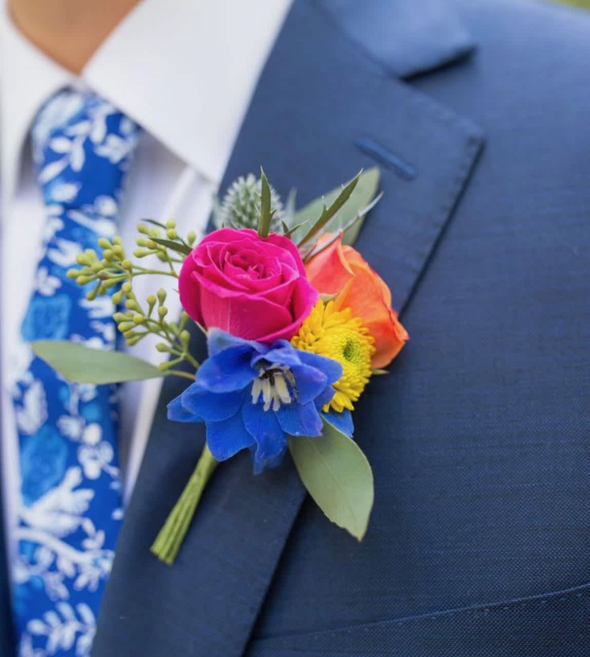 Colorful boutonniere pinned to a navy suit jacket