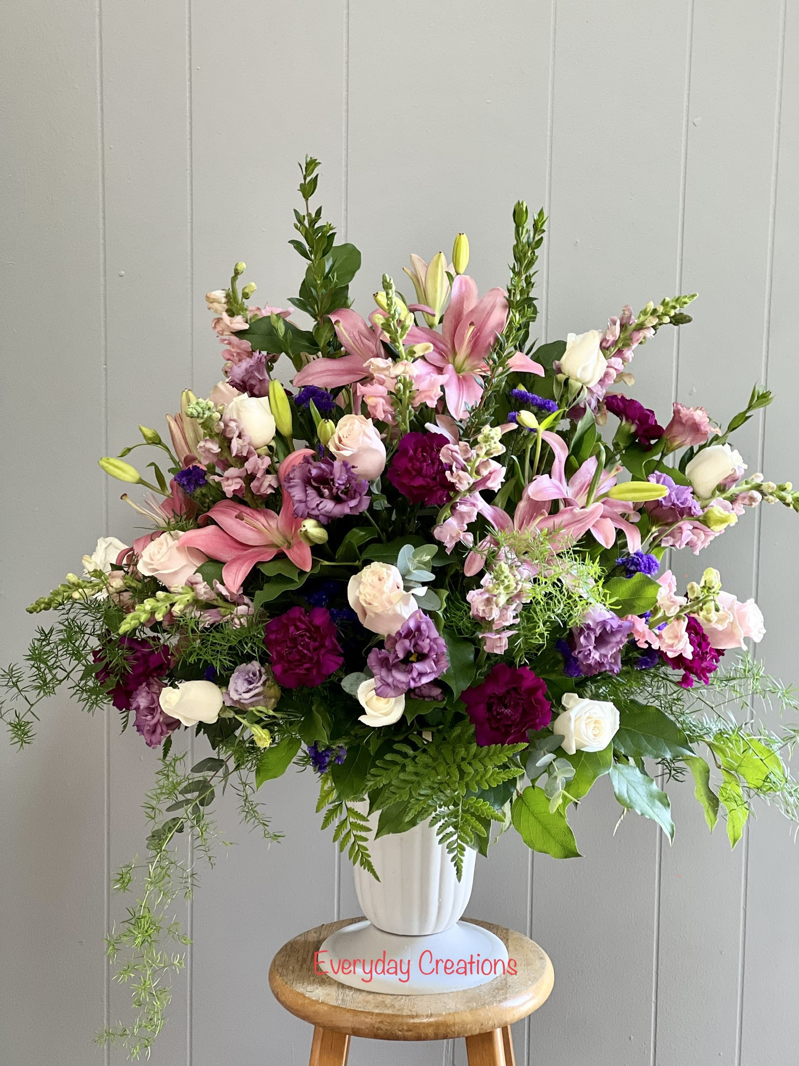 Large mixed bouquet of pink, white, and purple flowers in a white vase