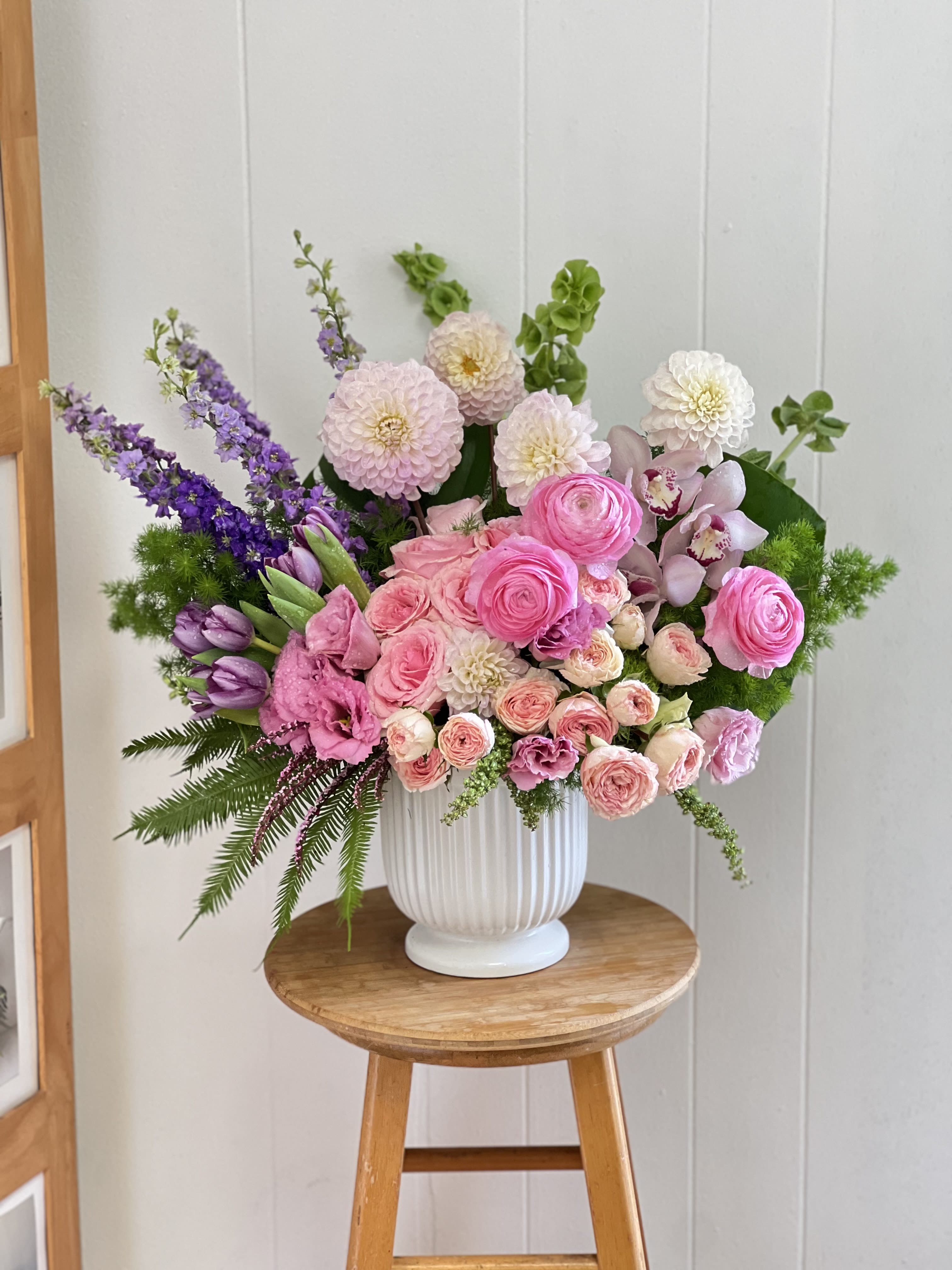 Pink and purple mixed flower arrangement in a white vase
