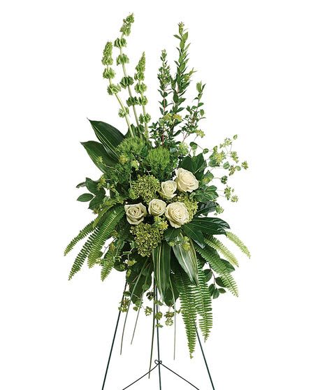 Tall standing floral spray with white roses and green foliage on a metal easel