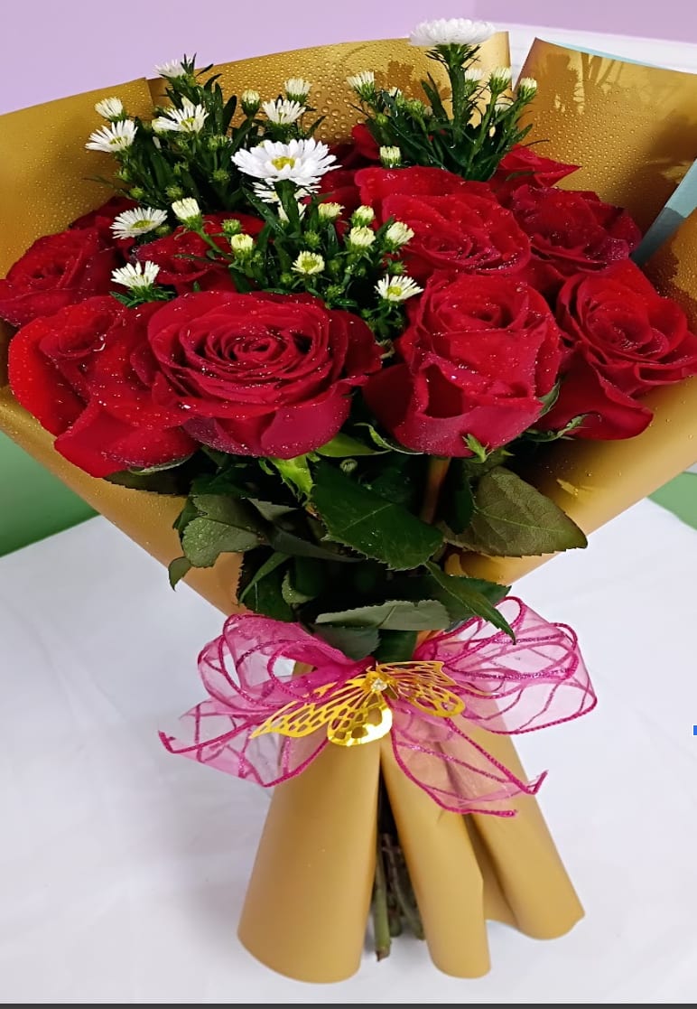 1 dozen elegant red roses wrapped in korean paper with decorations - Tightly clustered red roses take center stage in this one dozen red roses arrangement, making it an unmistakable choice for love and romance, anniversaries, or a heartfelt Valentine's Day gift. Small white daisy-like blooms peek through the red heads, softening the look and adding a fresh, cheerful touch that also suits birthdays, "just because" surprises, or a thoughtful "thinking of you" bouquet. The overall effect is romantic and celebratory-perfect for the person you want to make feel truly seen.  Wrapped in metallic gold paper and finished with a sheer pink ribbon and a decorative butterfly pick, this compact hand-tied bouquet reads as a polished, ready-to-present gift for Mother's Day, prom corsage alternatives, thank you gestures, or even a sincere "I'm sorry." The red roses deliver classic depth while the white daisies and pink accents brighten the composition; the bouquet's tidy, personal size makes it ideal for hand delivery or a bedside surprise. For care, keep stems in fresh water, trim an inch off stems every few days, and keep away from direct heat to prolong blooms.