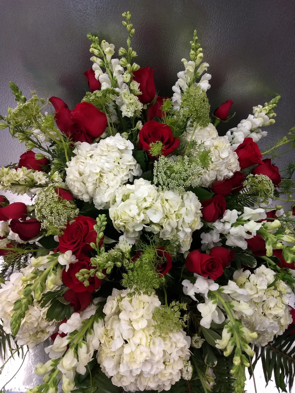 Red roses and white hydrangeas with white snapdragons in a large arrangement