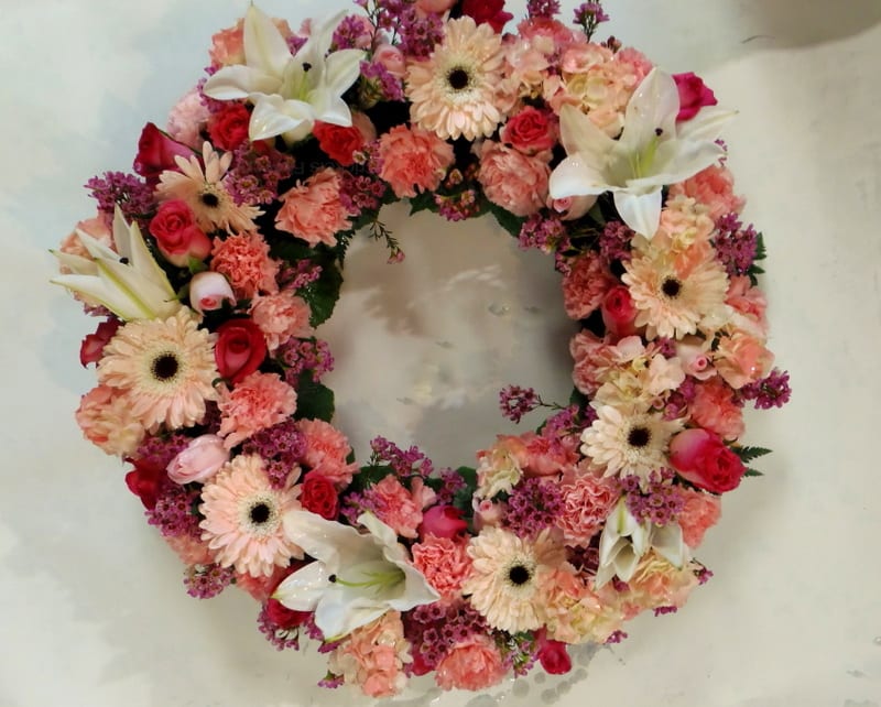 Circular floral wreath with pink, peach, and white flowers