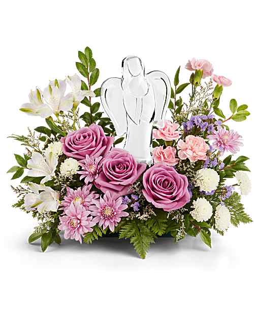 Lavender and pink flower arrangement with roses and a clear angel figurine in a low container