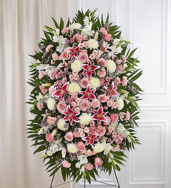 Standing floral spray with pink and white flowers on a black easel