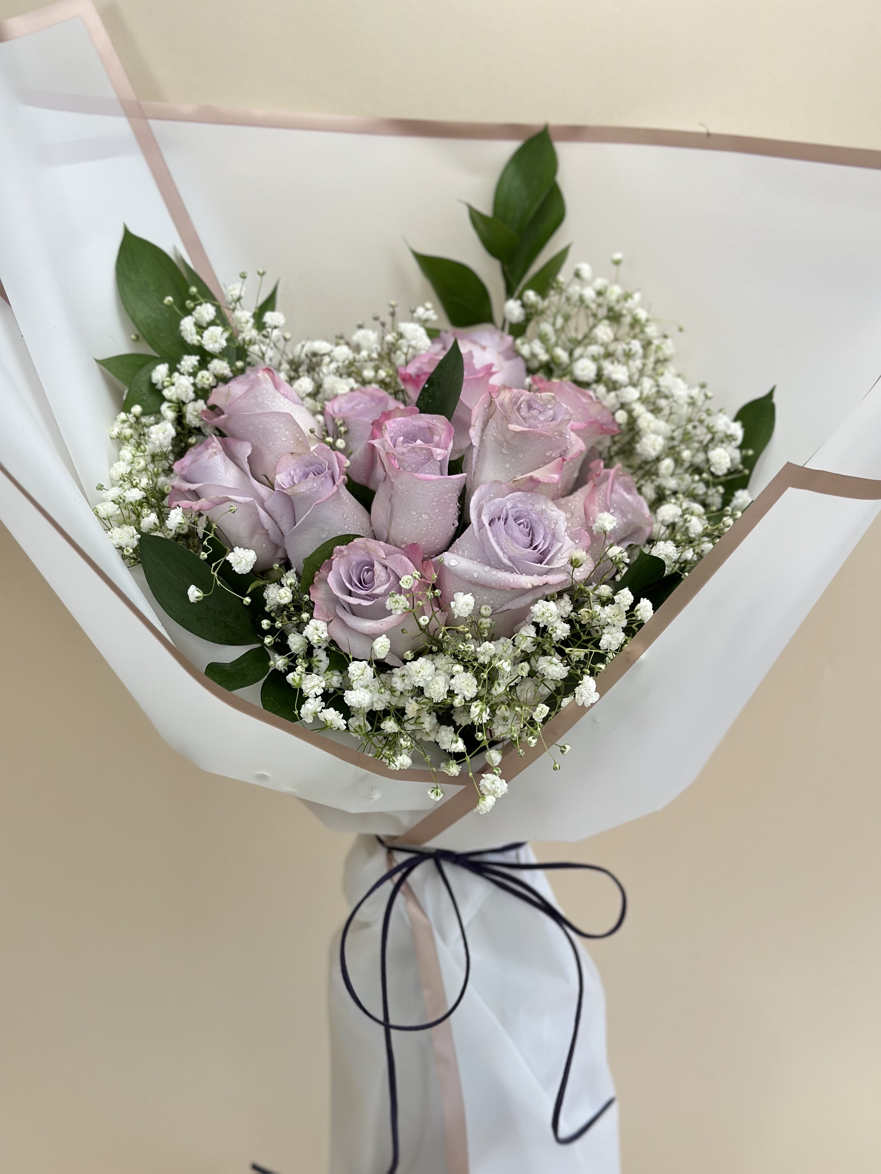 Lavender roses with baby's breath in white wrapping