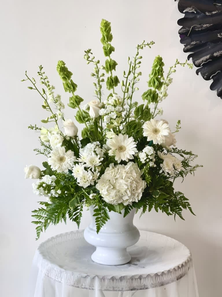 White floral arrangement in a white pedestal vase